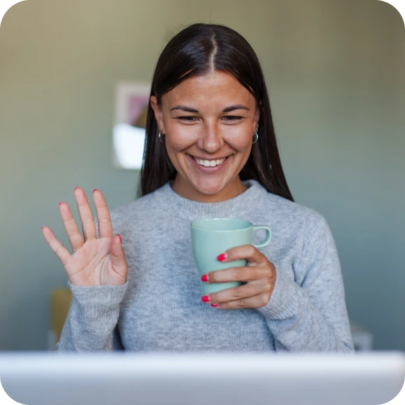 Woman logging into a call online with a coffee mug