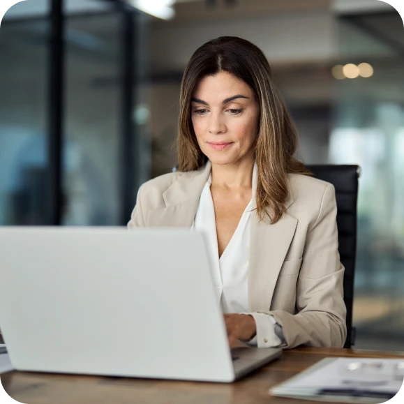 Woman sat in office at desk on laptop