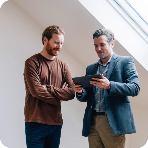Estate agent showing viewer something on his tablet during a house viewing