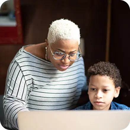 Mother closely supervising her child on a laptop